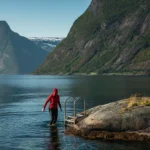 Sommer-vinterbading i Lofoten-fjord under midnattssolen