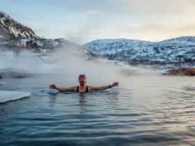 Norsk person som kommer opp fra iskaldt fjord om vinteren med damp stigende fra vannet