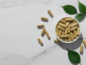 Magnesium malat og glysinat kapsler på hvit marmor med grønne blader