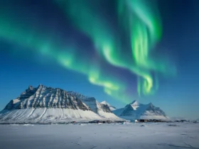 Svalbard midnattssol over arktisk landskap med nordlys