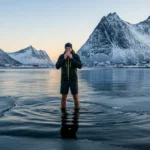 Mann praktiserer Wim Hof-metoden med isvann i Lofoten-fjord