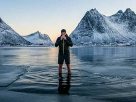 Mann praktiserer Wim Hof-metoden med isvann i Lofoten-fjord