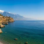 Solrik kystlinje i Antalya om vinteren med palmer og Middelhavet