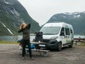 Person som tøyer nakke og rygg ved en bobil på rasteplass, illustrasjon til vondt i nakke bobil