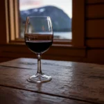 Et glass rødvin på et hyttebord, som illustrasjon til spørsmålet om rødvin er sunt