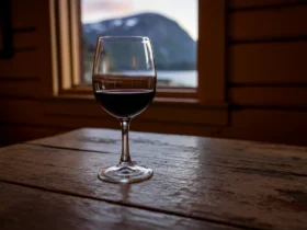 Et glass rødvin på et hyttebord, som illustrasjon til spørsmålet om rødvin er sunt
