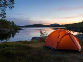 Telt satt opp ved en stille norsk innsjø i skumring, klart for å sove i telt